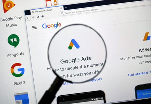 Magnifying glass highlighting the Google Ads logo and text